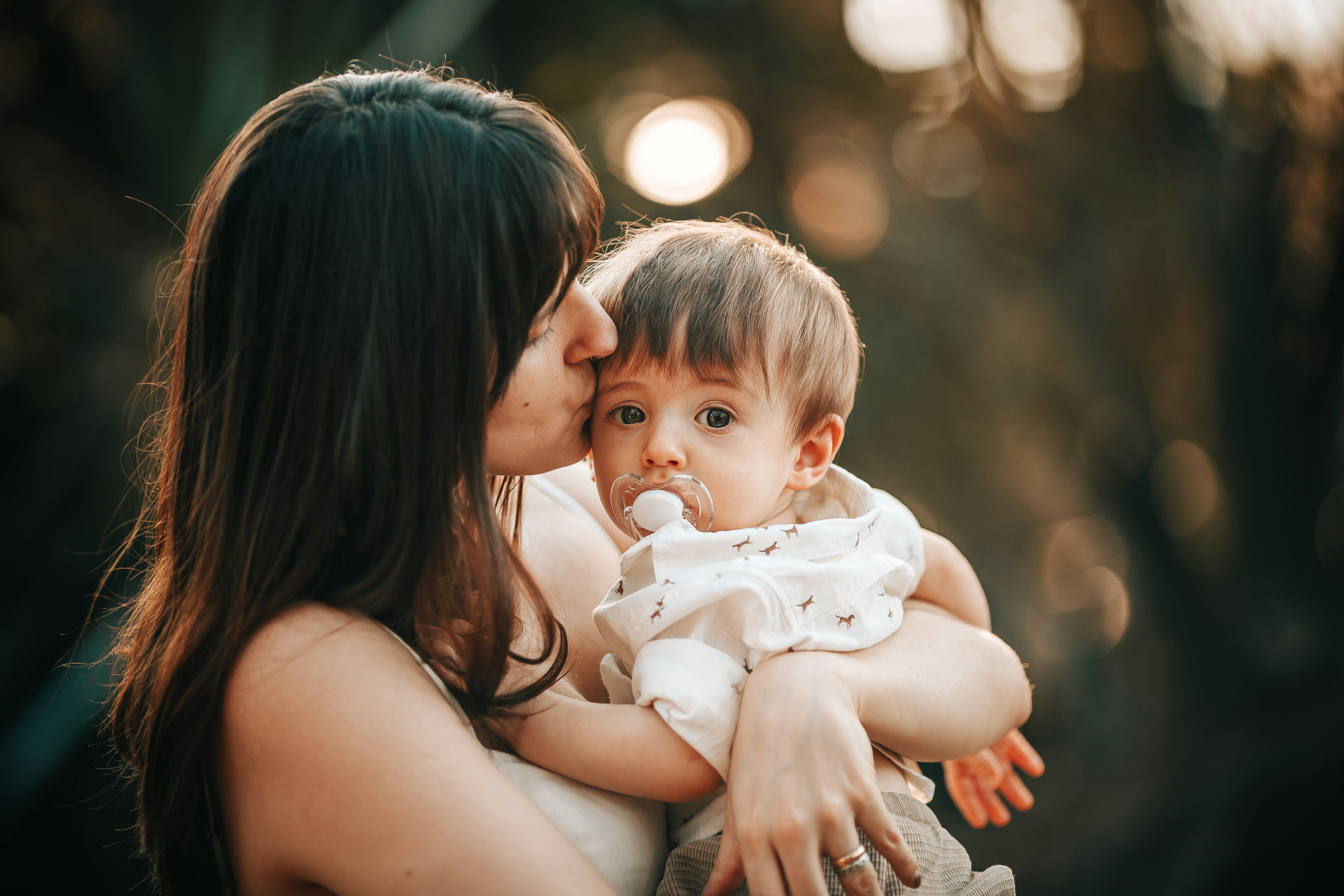 woman in black tank top carrying baby in white tank top